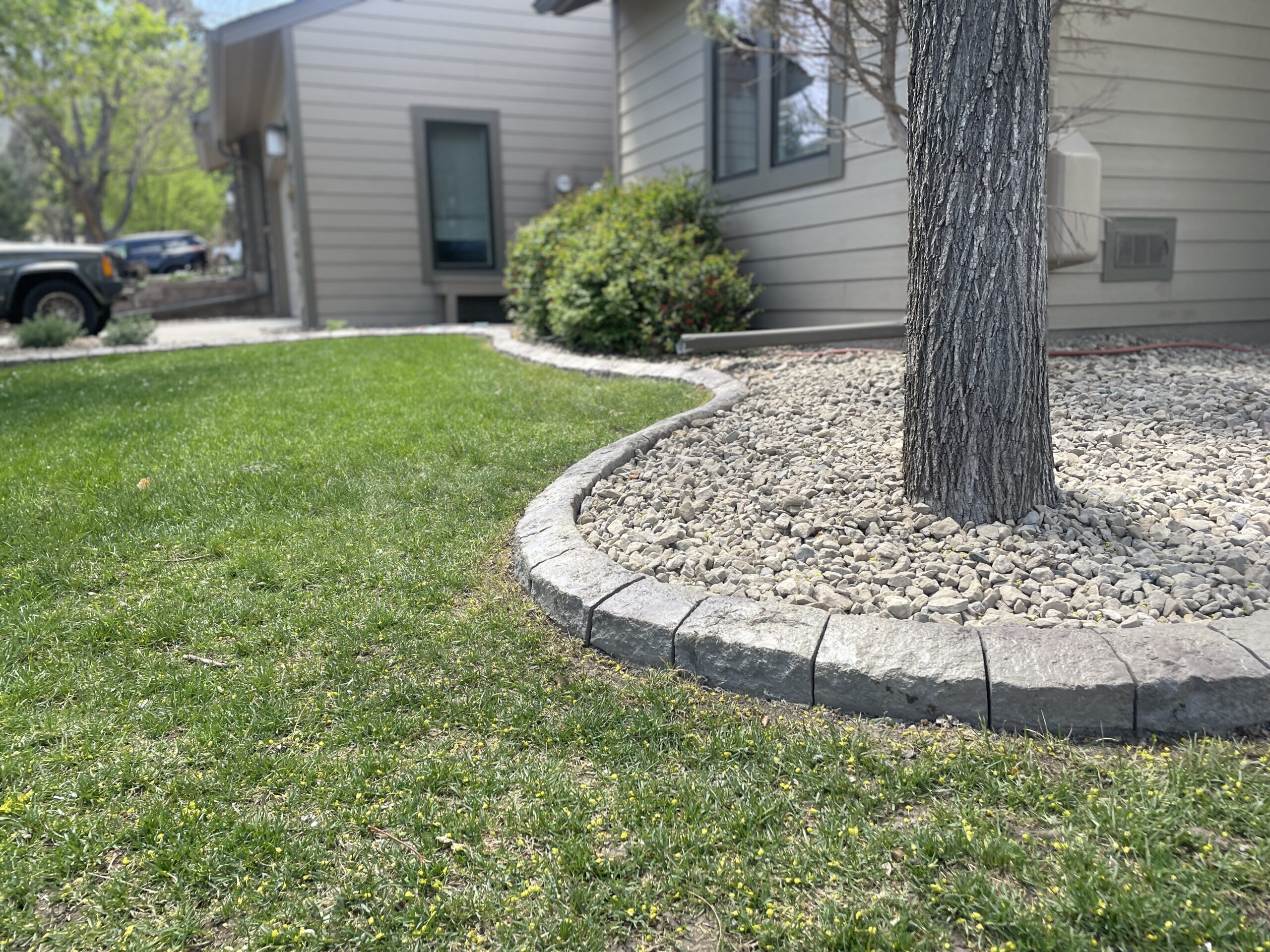 Curved concrete landscape edging along a pathway at Woodbridge Townhomes, providing clean lines and aesthetic appeal.